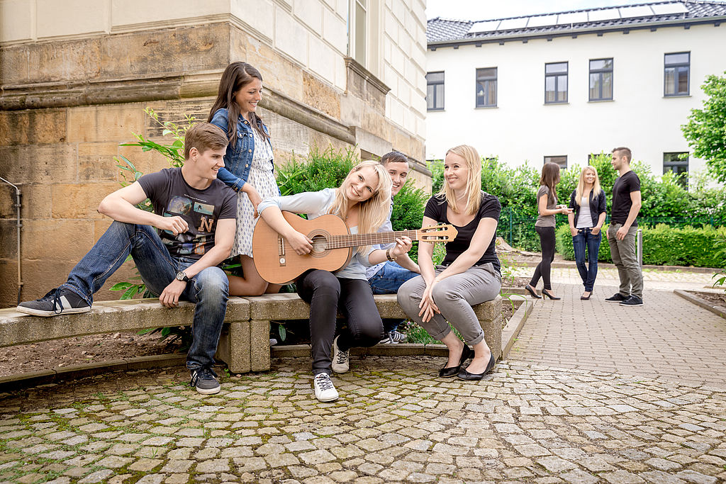 Studierende mit Gitarre vor Haus 3