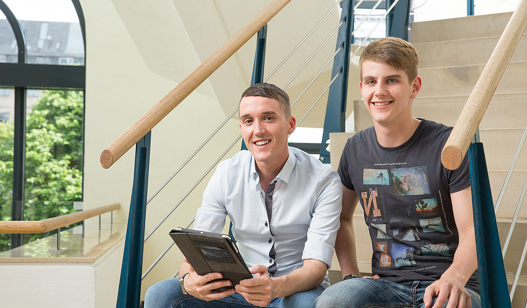 Zwei Studenten mit Tablet auf Treppe